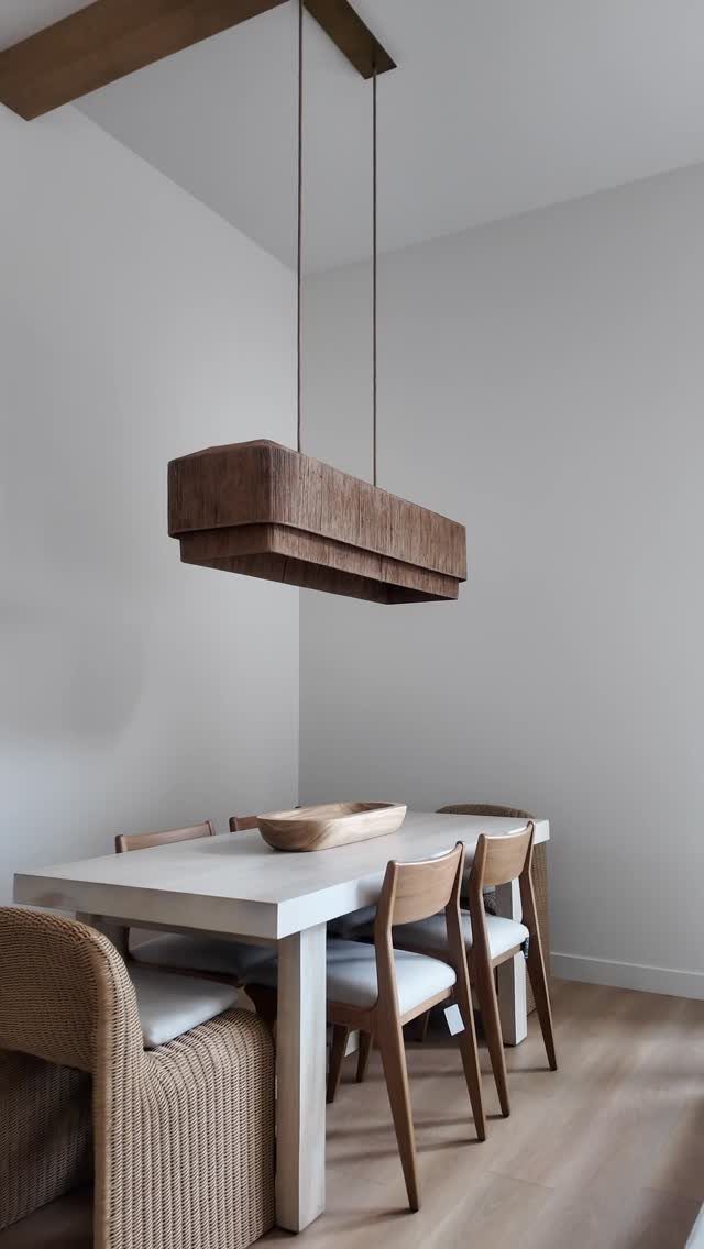 Dining table with wooden side chairs and a woven wicker head chair.