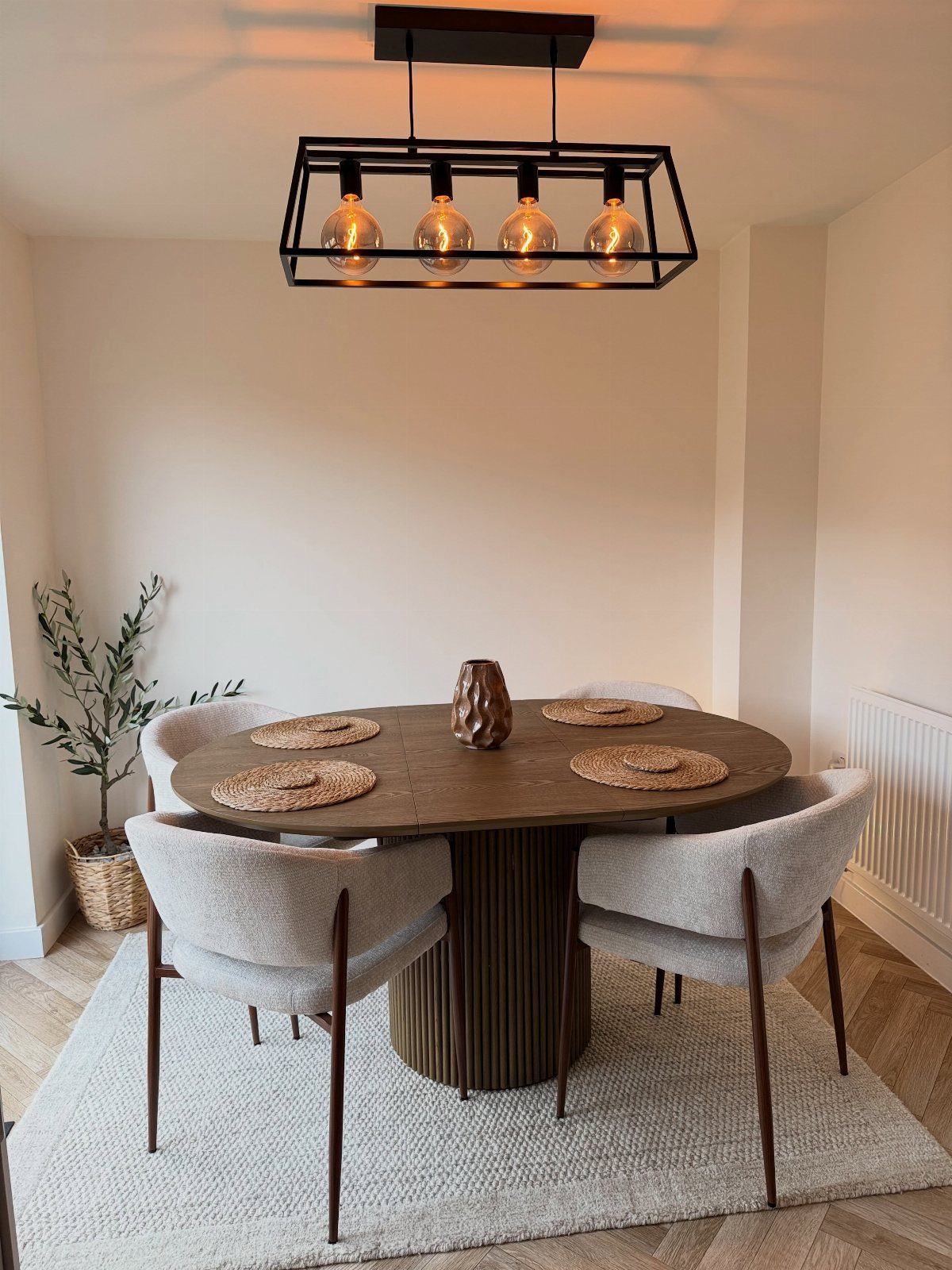 7 Dining Room Table Ideas for a Standout Space 6 Oval wooden dining table with grey upholstered chairs and a black pendant light.