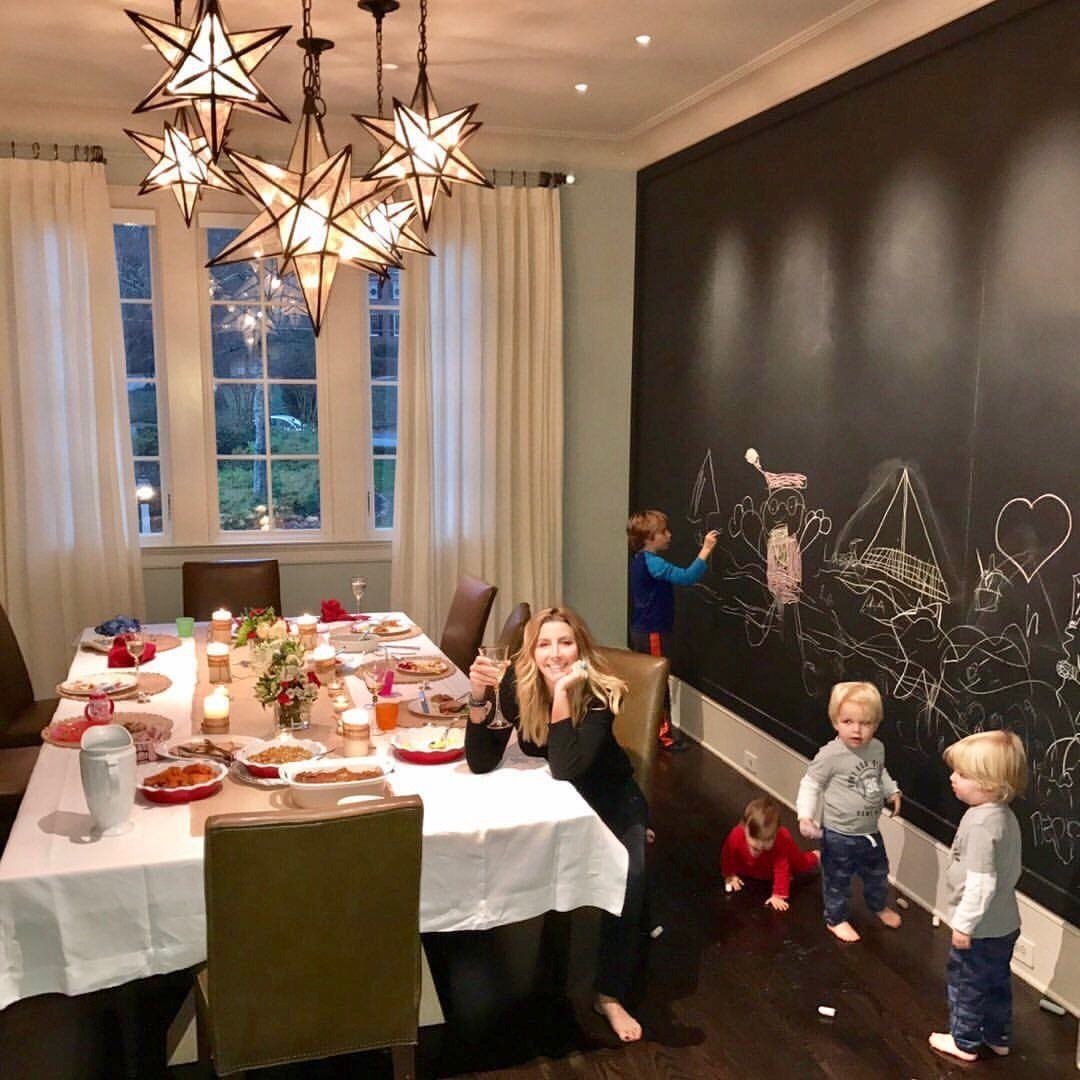 Large black chalkboard wall with children's drawings in a decorated dining room