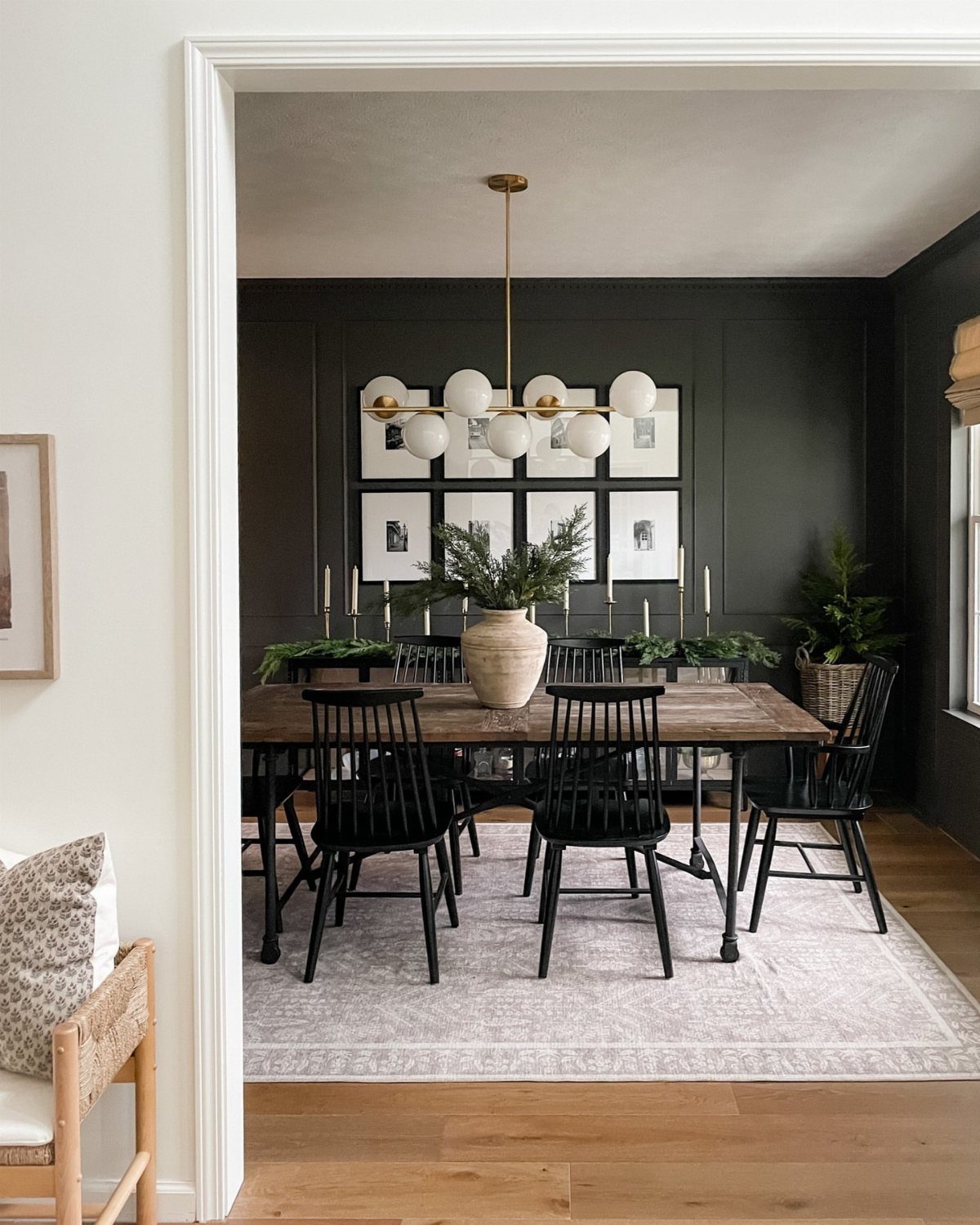 Dining room with dark walls, picture frame molding, and a wooden dining table.
