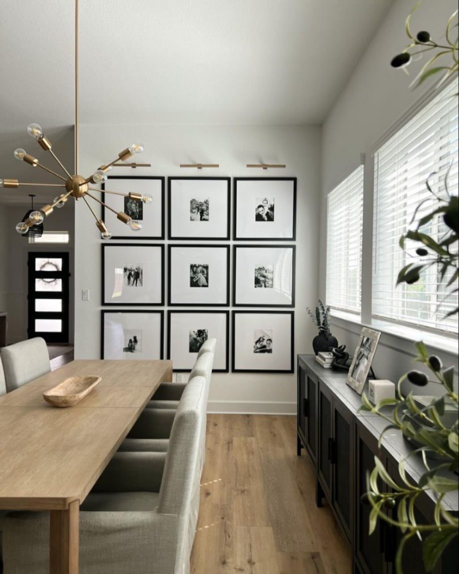 Grid of nine black-framed black and white photos on a dining room wall