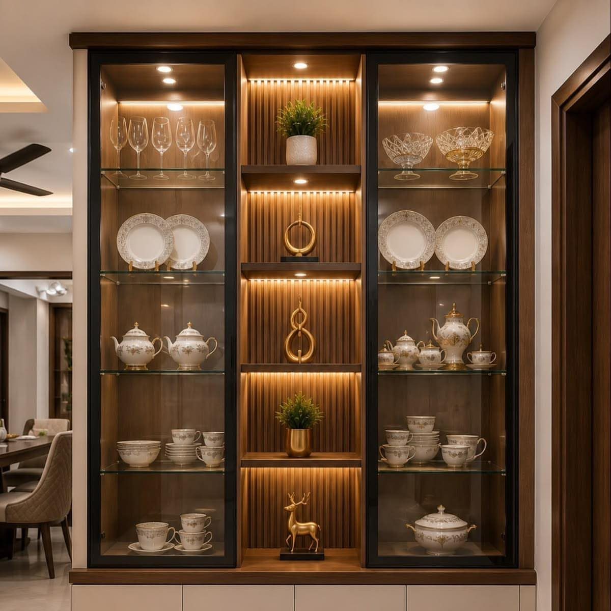Built-in wooden buffet with glass cabinets displaying white china and gold decor.
