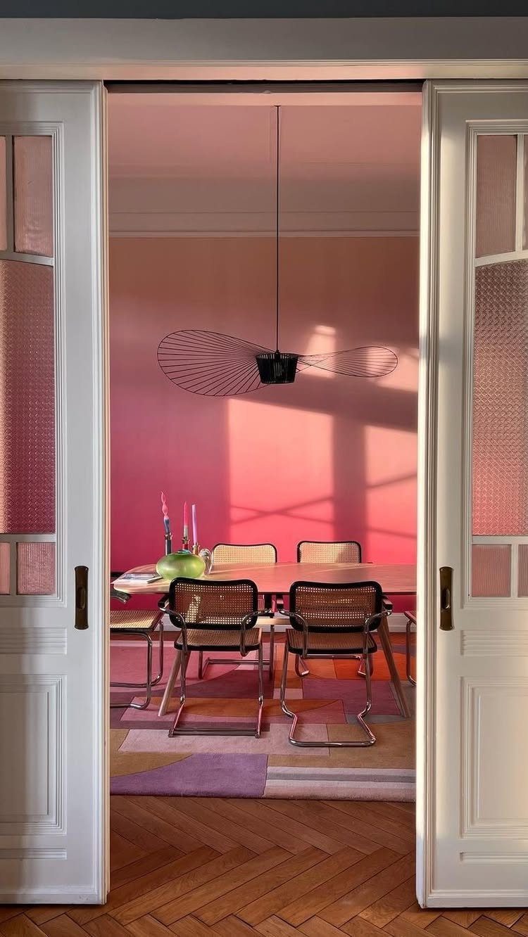 5 Dining Room with Carpet Ideas to Refresh Your Space 3 Dining room with a colorful geometric rug, pink walls, and modern furniture.