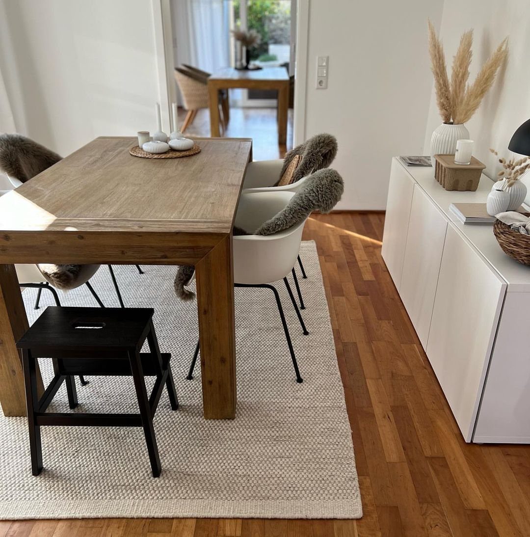 5 Dining Room with Carpet Ideas to Refresh Your Space 2 Wooden dining table and white chairs on a light beige minimalist textured rug.