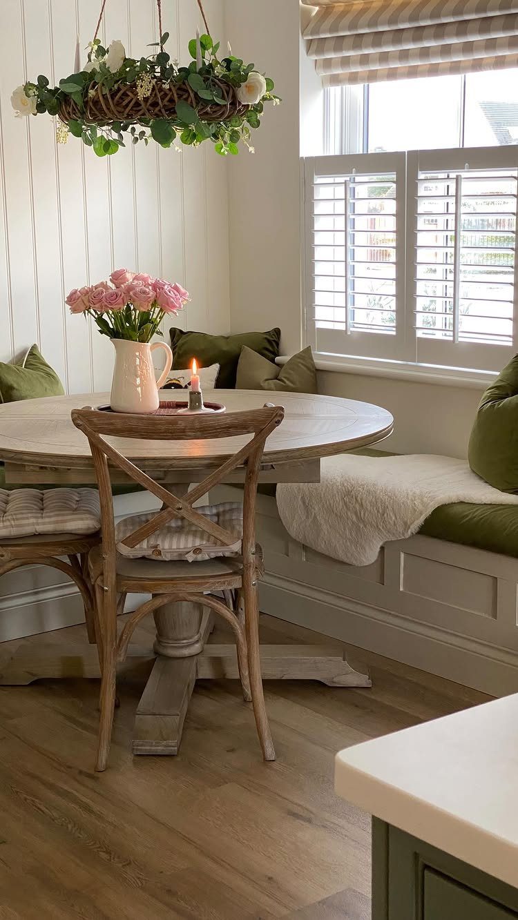 10 Dining Table in Living Room Ideas for Small Spaces 6 Round wooden dining table with a built-in banquette seat and green cushions.