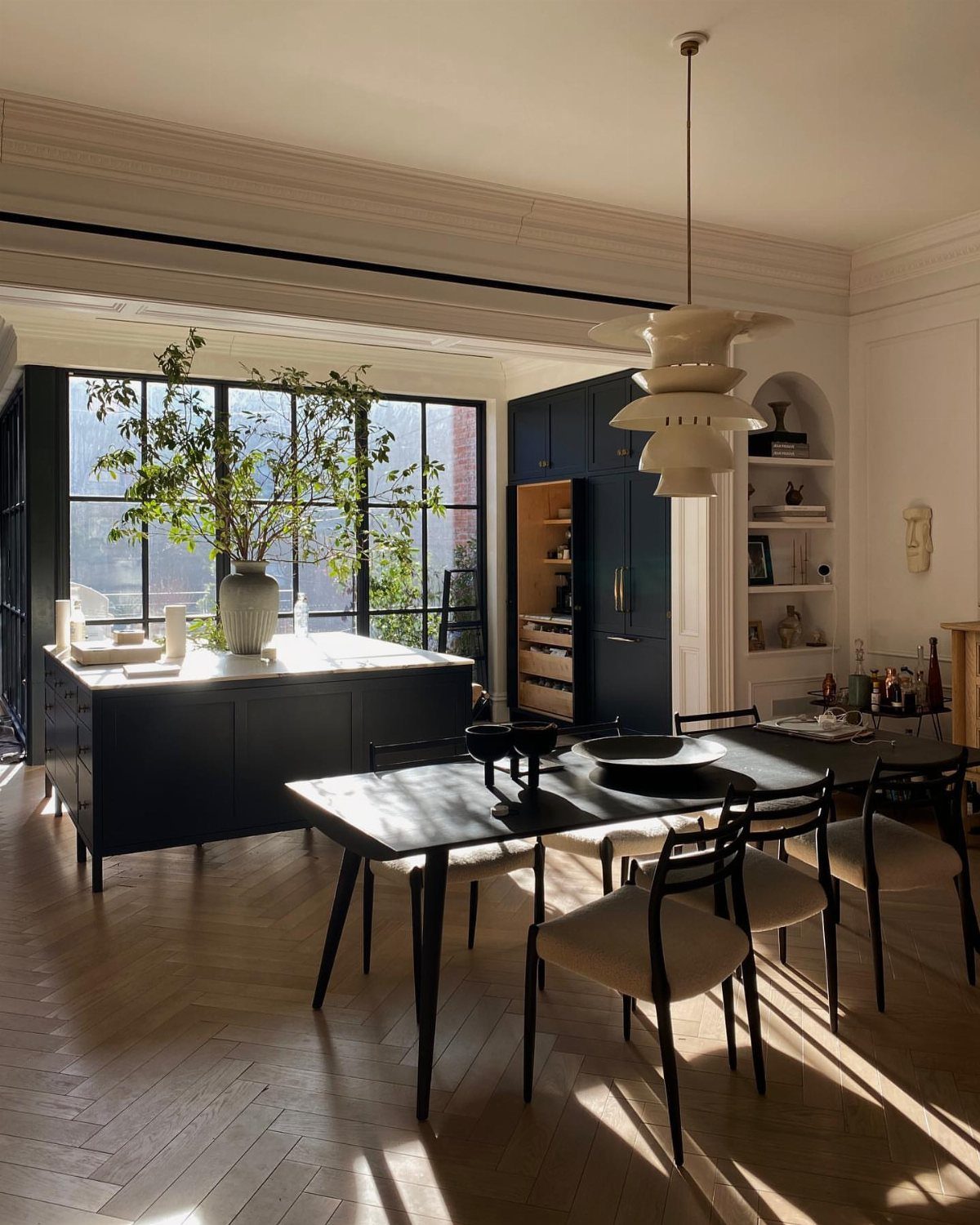 10 Dining Table in Living Room Ideas for Small Spaces 1 Black dining table and matching black kitchen island in a bright, open living space