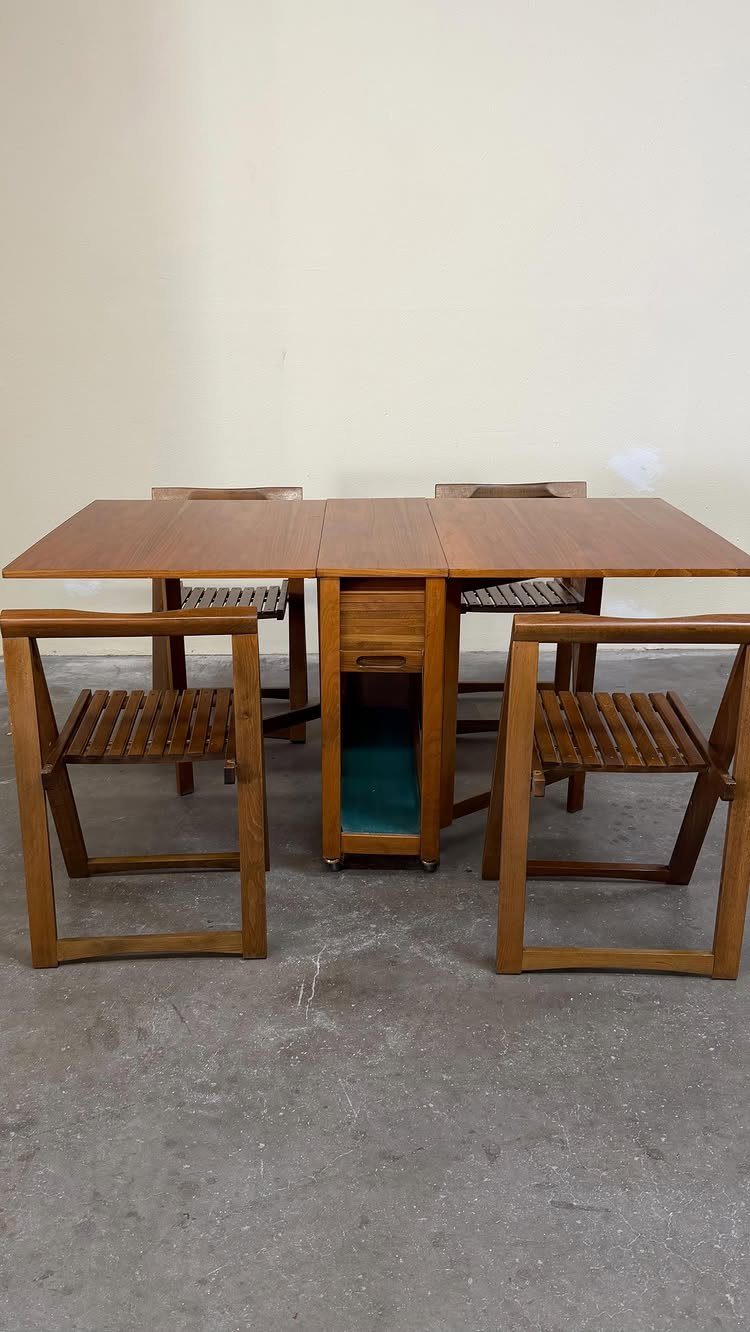 11 Dining Table Ideas for Small Spaces That Maximize Room 5 Wooden dining table with central storage and four matching slatted chairs in a room.