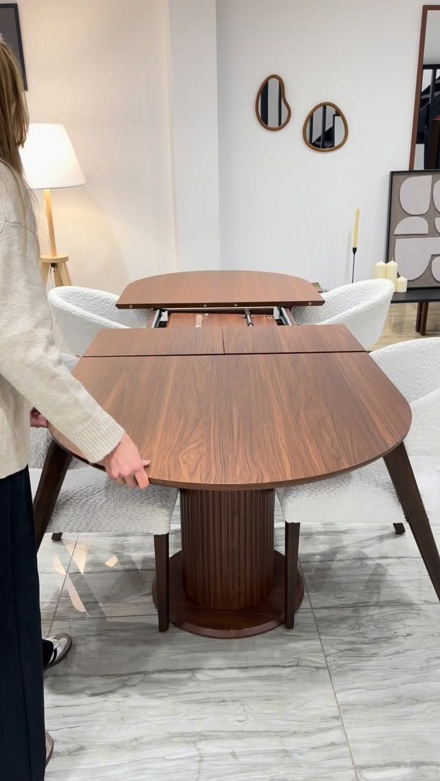 11 Dining Table Ideas for Small Spaces That Maximize Room 6 Expandable brown wooden dining table being opened in a modern white room.