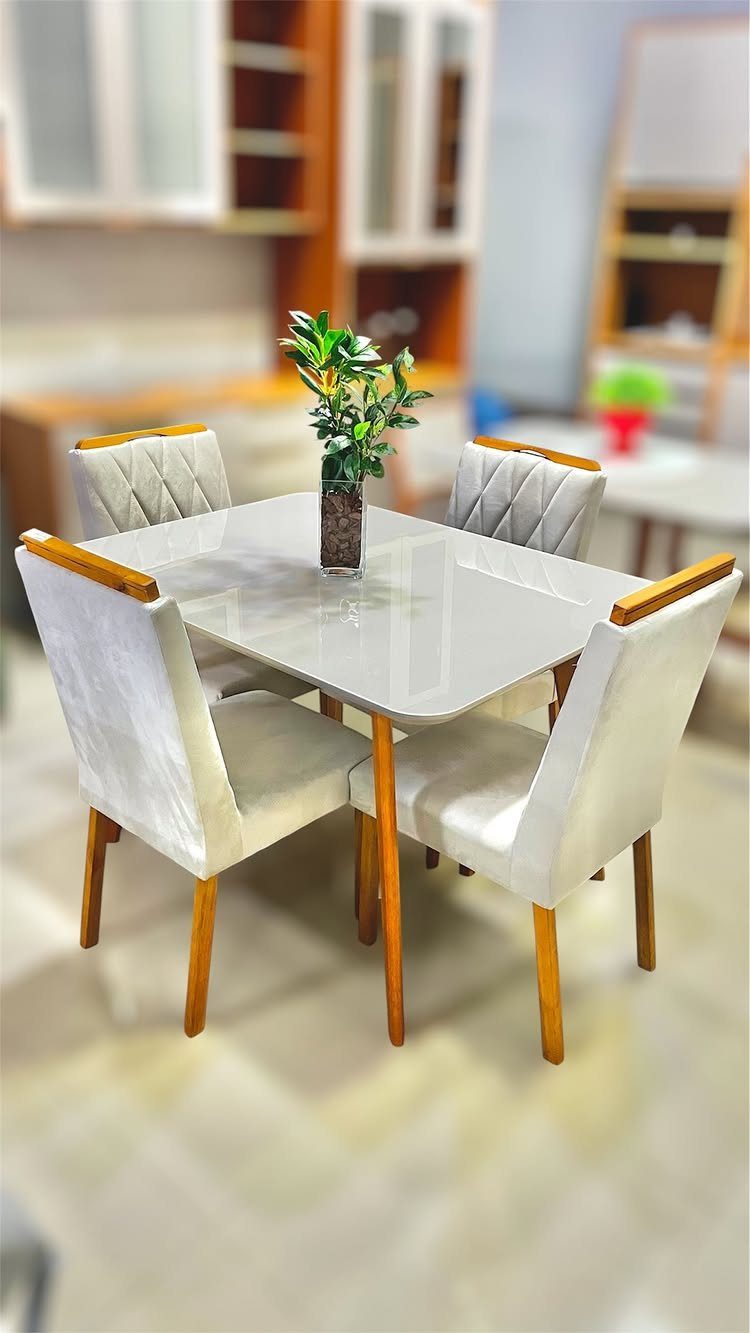 11 Dining Table Ideas for Small Spaces That Maximize Room 8 Small square white dining table with four white chairs and a small plant.