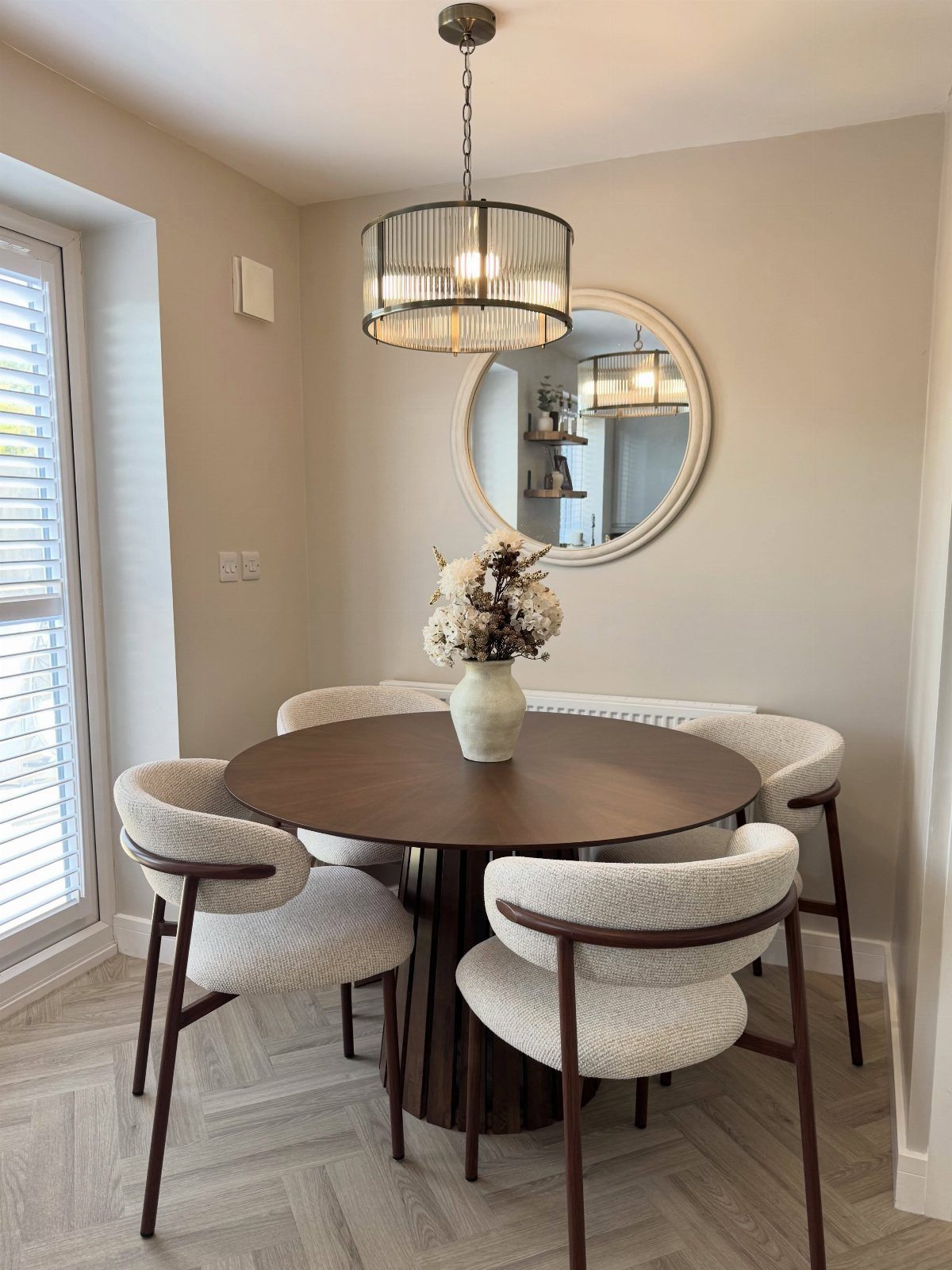 11 Dining Table Ideas for Small Spaces That Maximize Room 1 Round dark wood dining table with white upholstered chairs in a small room