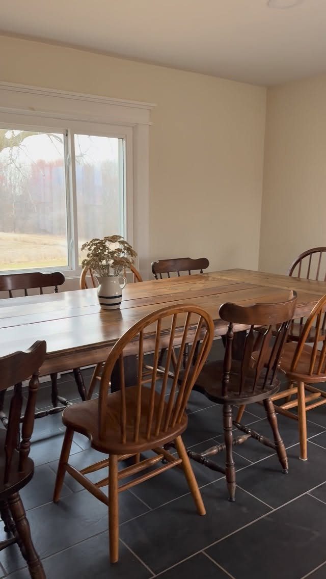 7 Dining Table with Mismatched Chairs Ideas That Work 5 Wooden dining table with various mismatched wooden chairs on a dark tiled floor