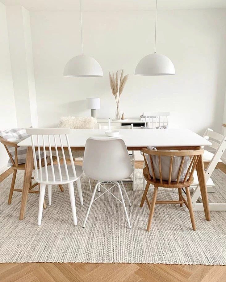 7 Dining Table with Mismatched Chairs Ideas That Work 7 White dining table with a variety of mismatched white and wooden chairs.