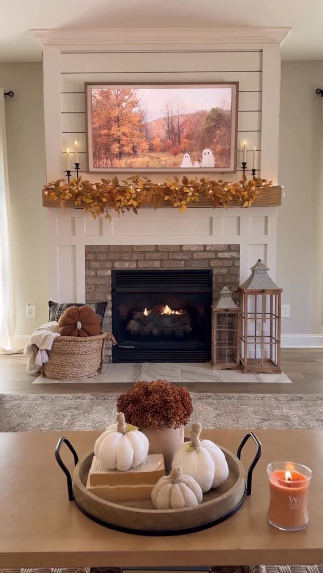 16 Fall Fireplace Mantel Decor Ideas with Photos 14 Autumn decorated fireplace mantel with orange leaves, white pumpkins, and fall landscape art.