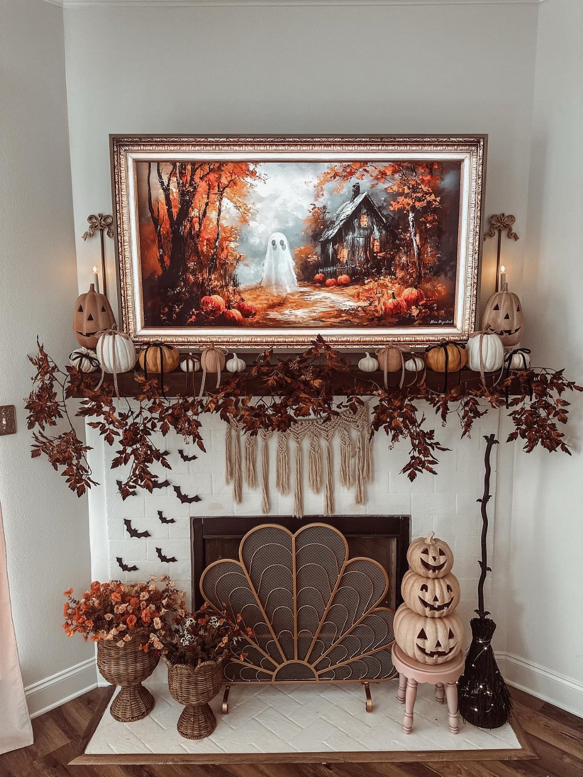 16 Fall Fireplace Mantel Decor Ideas with Photos 13 Autumn decorated white brick fireplace with pumpkins, leaf garland, and haunted house painting.