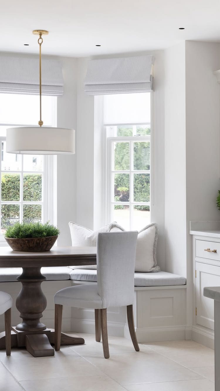13 Formal Dining Room Ideas for an Elegant Space 7 White built-in banquette seating inside a bay window with a wooden dining table.