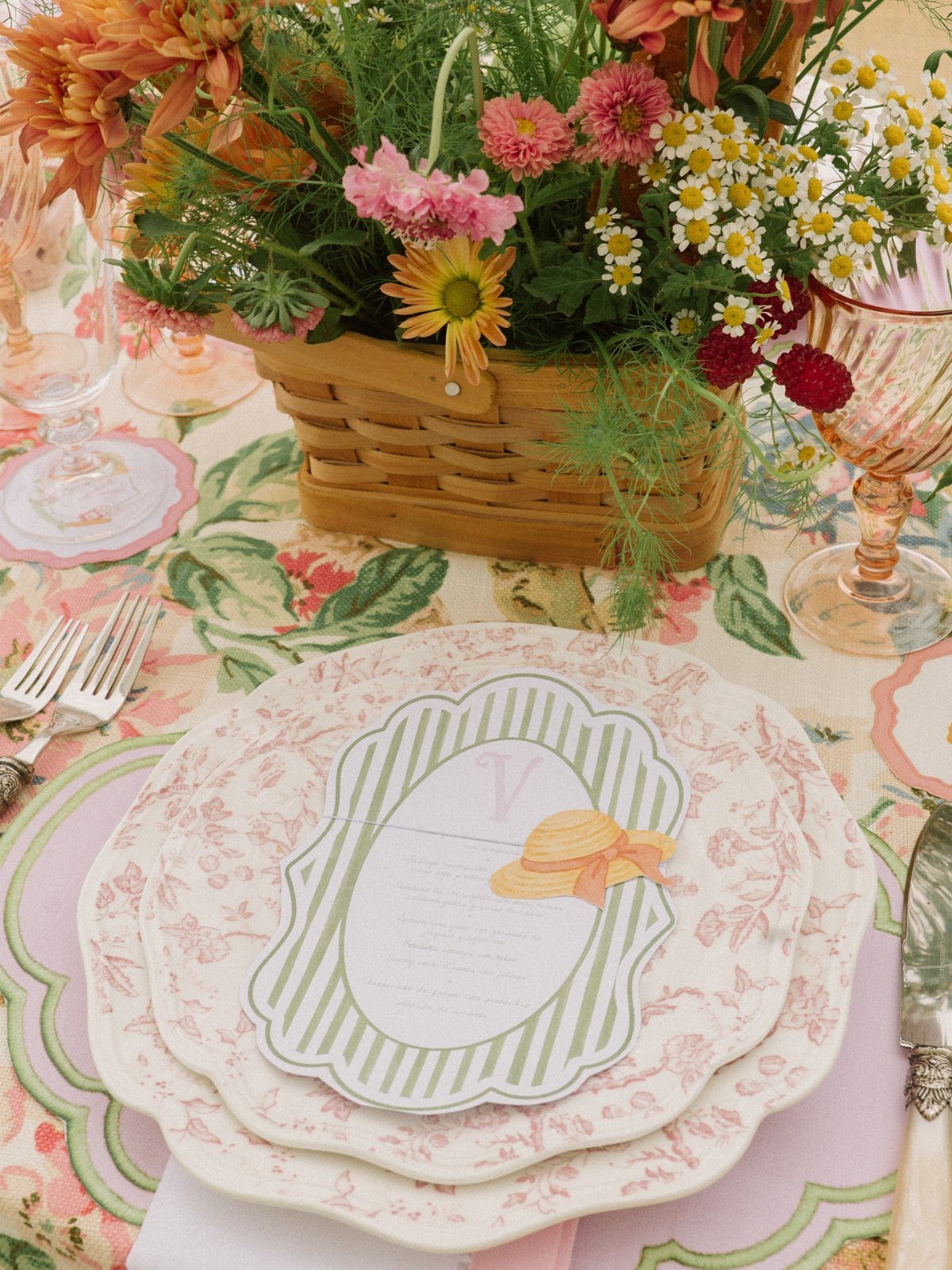 22 French Country Dining Room Ideas with Rustic Charm 6 Floral print tablecloth and plates with a basket of colorful wildflowers and glassware.
