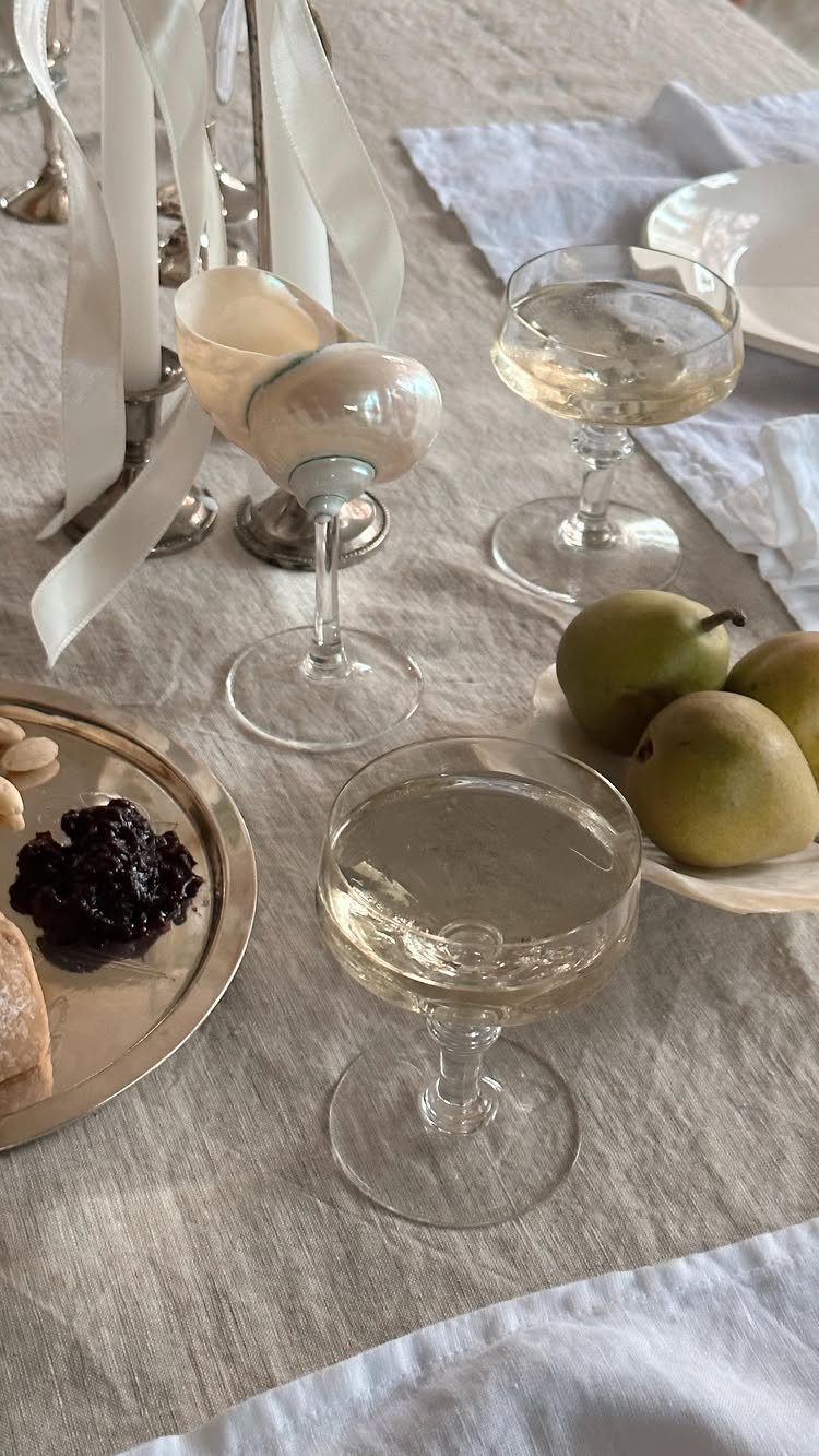 22 French Country Dining Room Ideas with Rustic Charm 17 Dining table set with linen cloth, white wine glasses, and fresh green pears.
