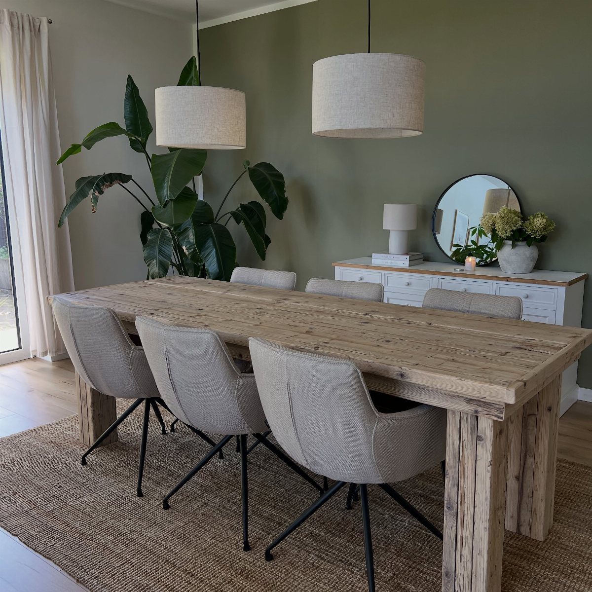 11 Green Painted Dining Room Ideas with Photos 9 Rustic wooden dining table with grey chairs against an olive green painted wall.
