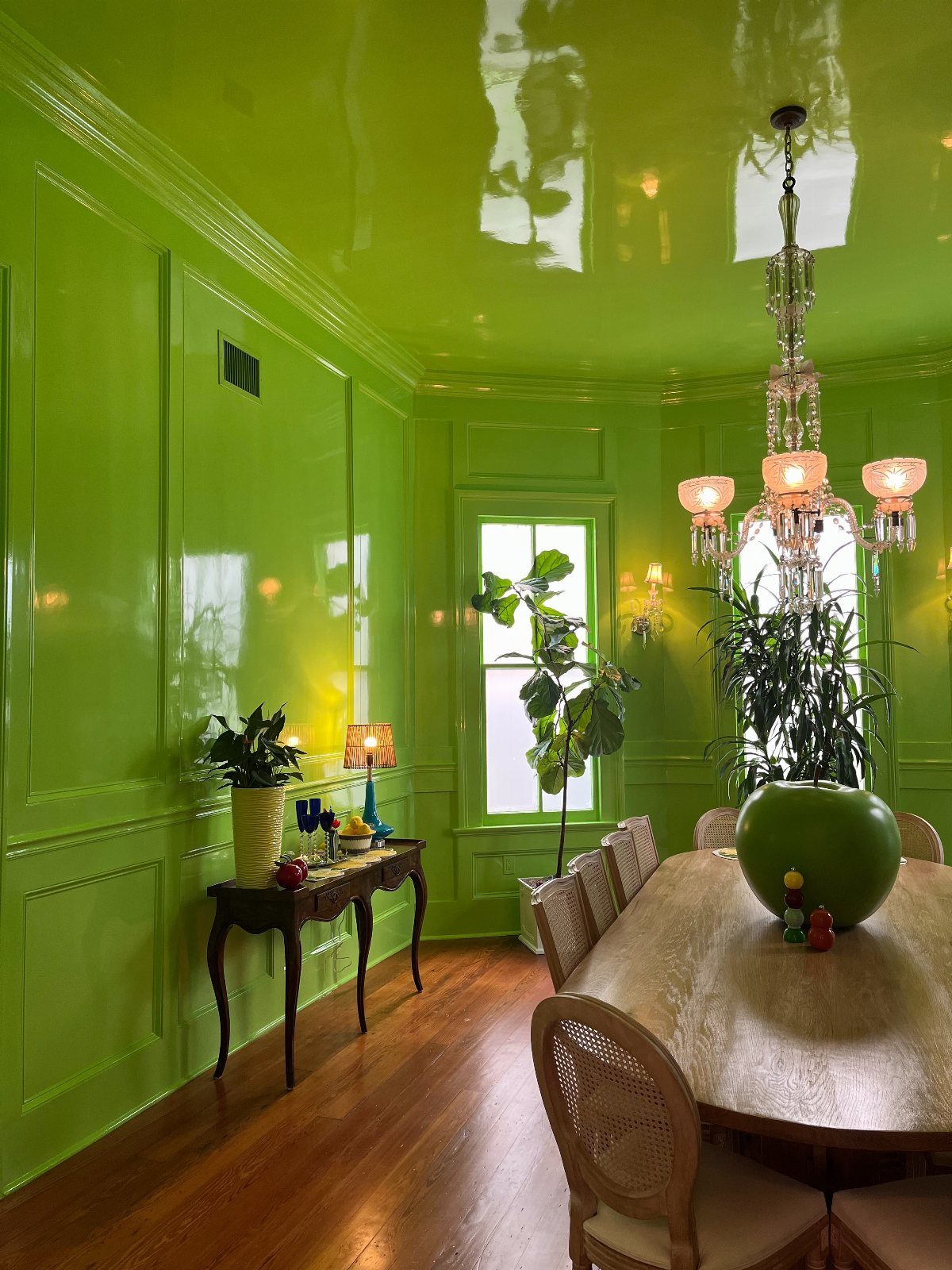 11 Green Painted Dining Room Ideas with Photos 1 Lime green dining room with matching walls, ceiling, and woodwork and a crystal chandelier.