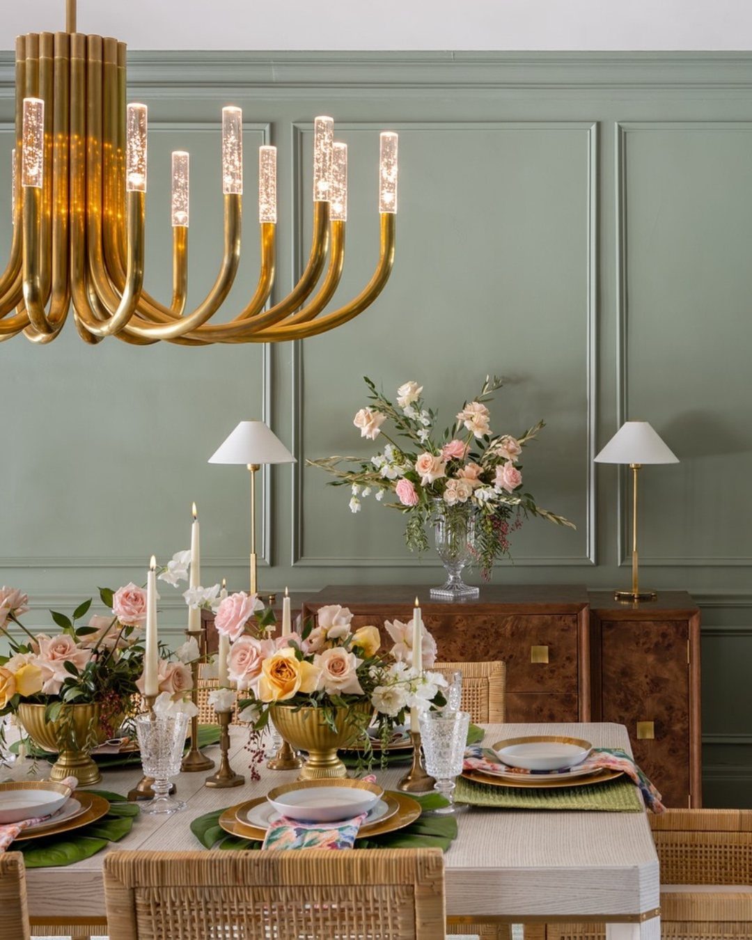 9 Green Walls for Dining Room Ideas with Photos 8 Gold chandelier hanging in a dining room with sage green paneled walls and flowers.