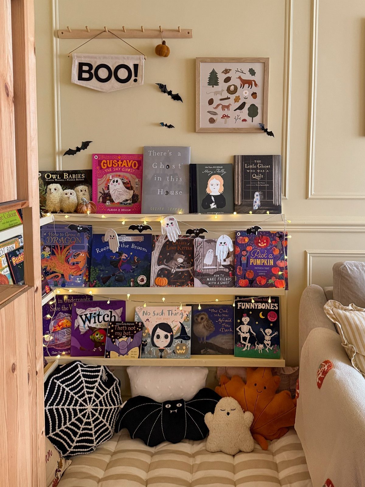 16 Halloween Room Decor Ideas to Set the Scene 4 Cozy Halloween reading nook with themed books, fairy lights, and spooky plush pillows.