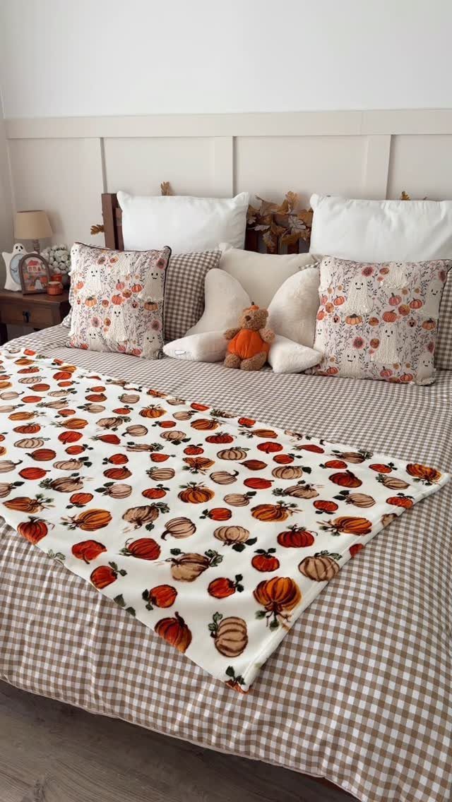 16 Halloween Room Decor Ideas to Set the Scene 5 Bed with pumpkin patterned blanket and pillows on a checkered duvet