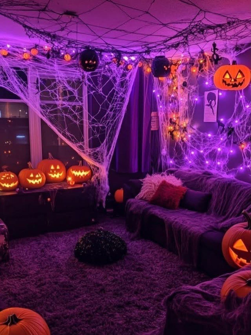 16 Halloween Room Decor Ideas to Set the Scene 16 Halloween decorated room with purple lights, carved pumpkins, and large white spider webs.