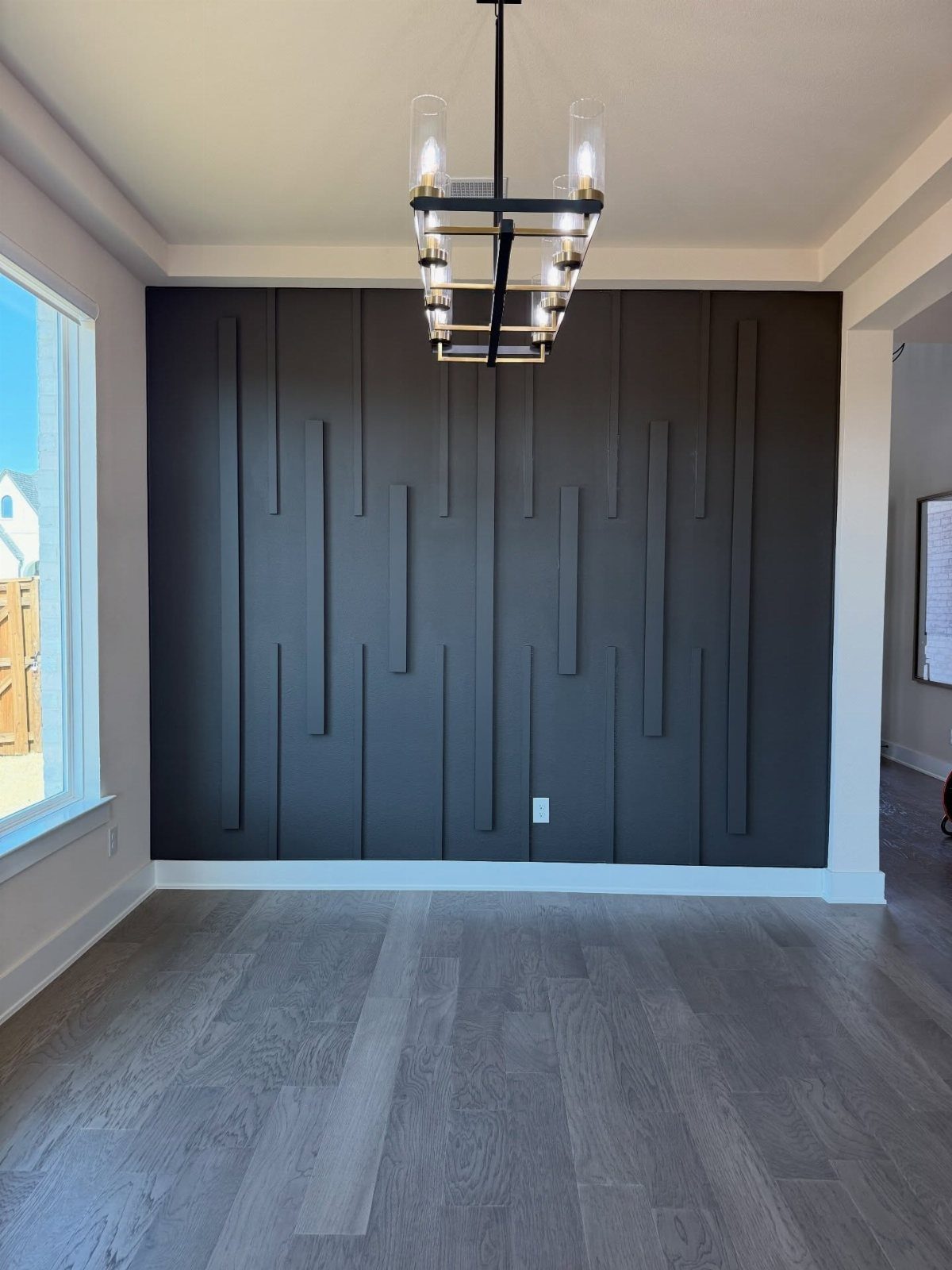 11 Living Dining Room Combo Ideas for Small Spaces 5 Dark grey accent wall with vertical slats and a modern gold chandelier.