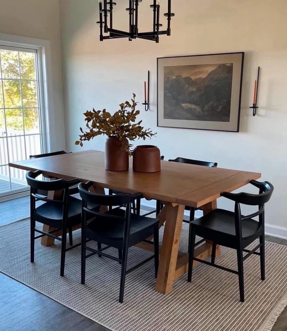 12 Living Dining Room Decor Ideas for Combined Spaces 1 Wooden dining table and black chairs on a grey rug in a bright room.