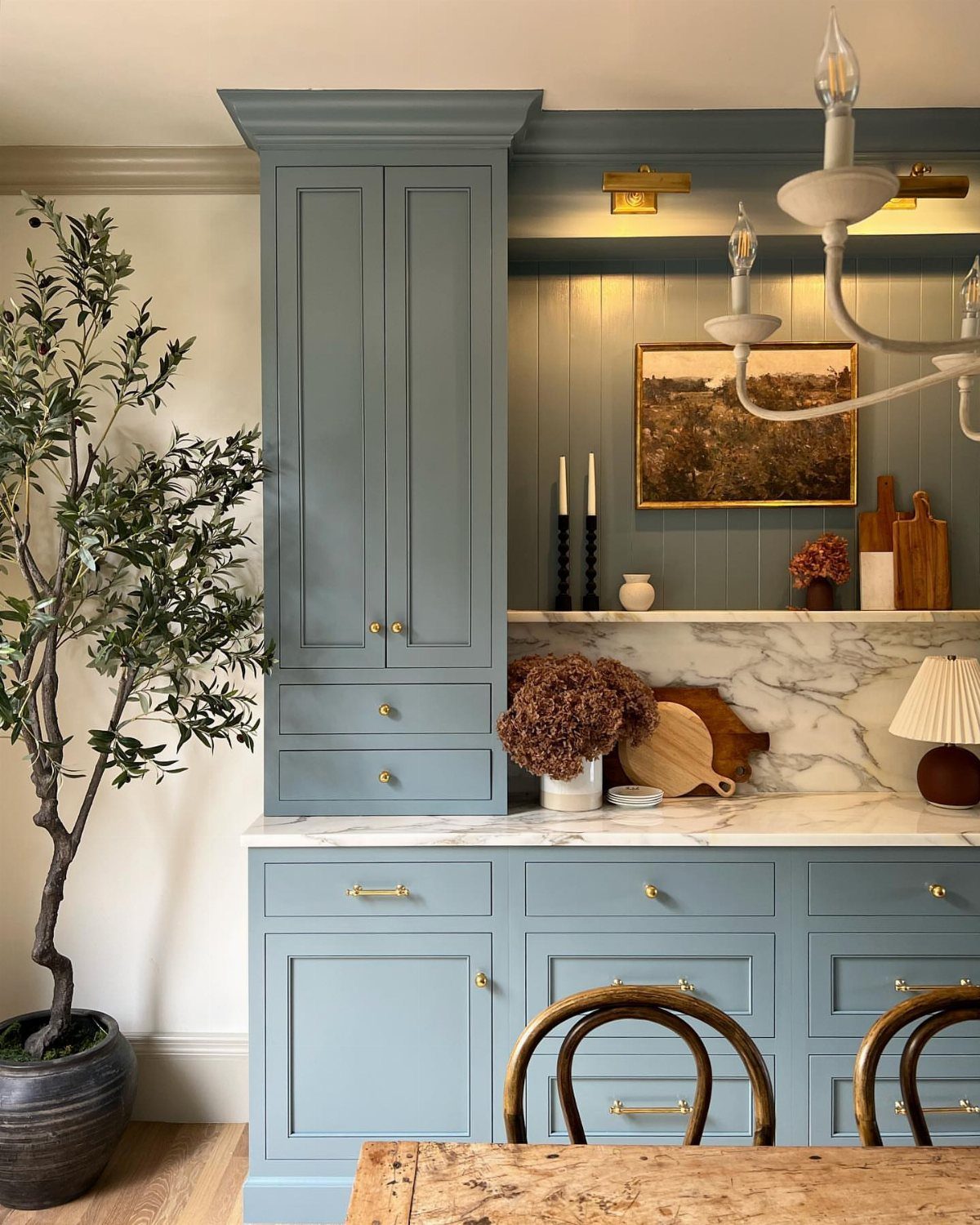 12 Living Dining Room Decor Ideas for Combined Spaces 12 Blue built-in kitchen hutch with marble countertop and a potted olive tree.