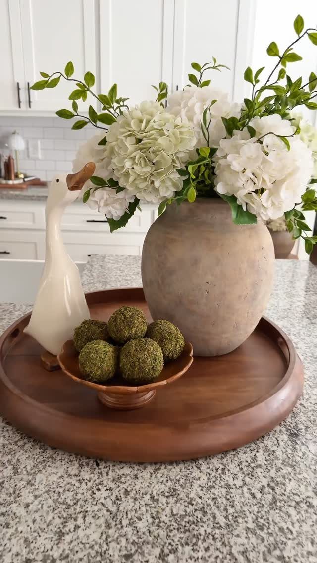 12 Living Dining Room Decor Ideas for Combined Spaces 6 White hydrangeas in a stone vase and moss balls on a wooden tray.