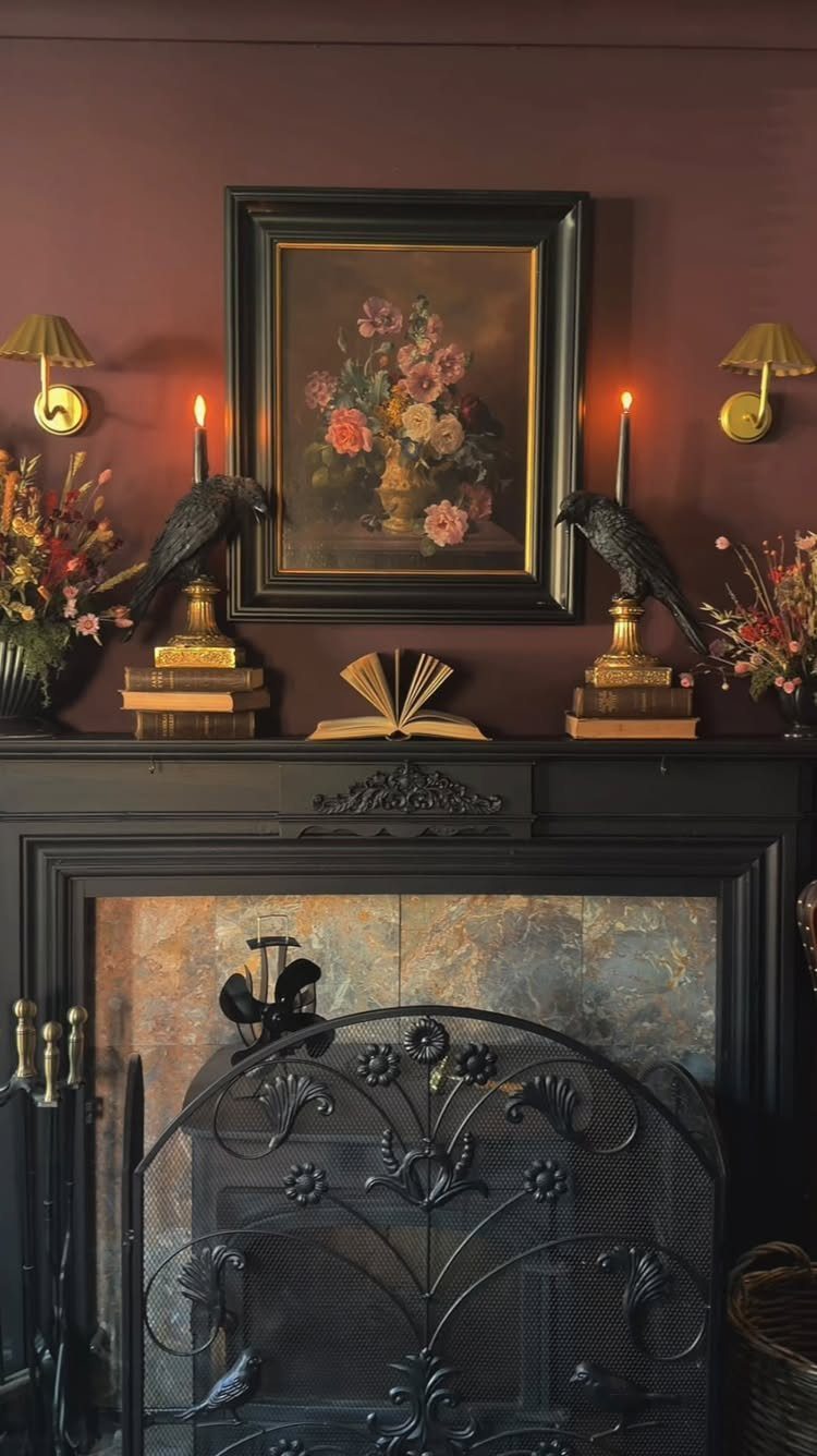 Decorated black fireplace mantel with floral art, candles, and bird figurines against burgundy wall