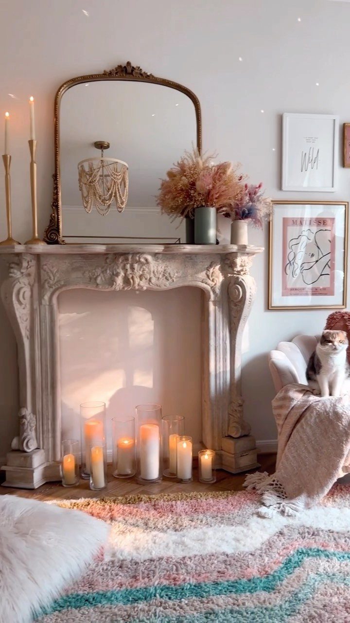 Ornate stone fireplace mantel with a gold mirror and dried flower arrangements.