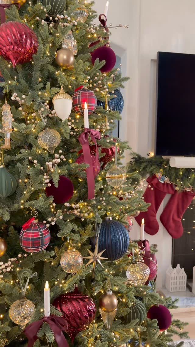 14 Modern Christmas Living Room Ideas with Photos 13 Decorated Christmas tree with red and gold ornaments next to a festive fireplace.