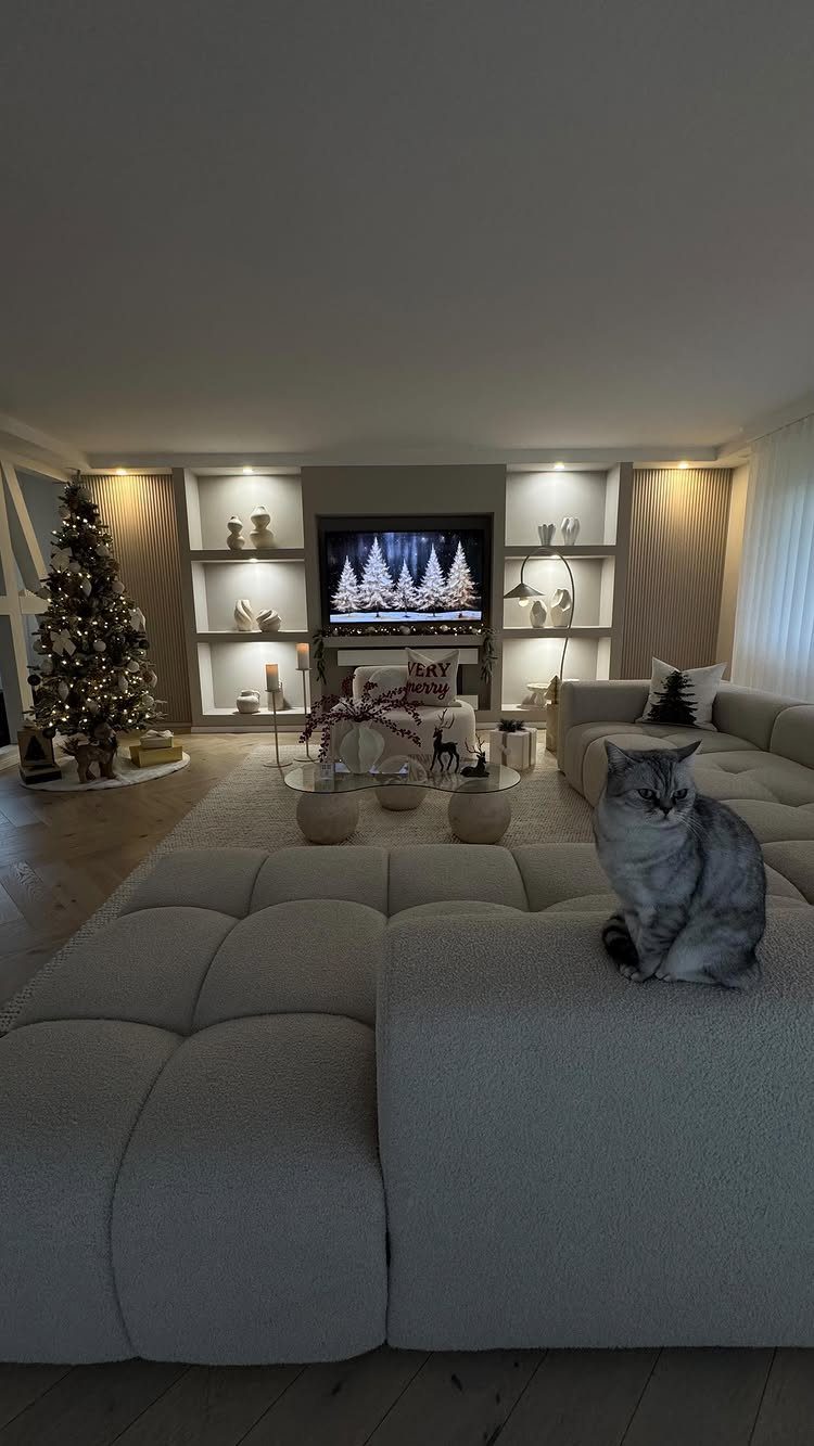 14 Modern Christmas Living Room Ideas with Photos 11 Modern living room with a grey sofa, Christmas tree, and a grey cat.