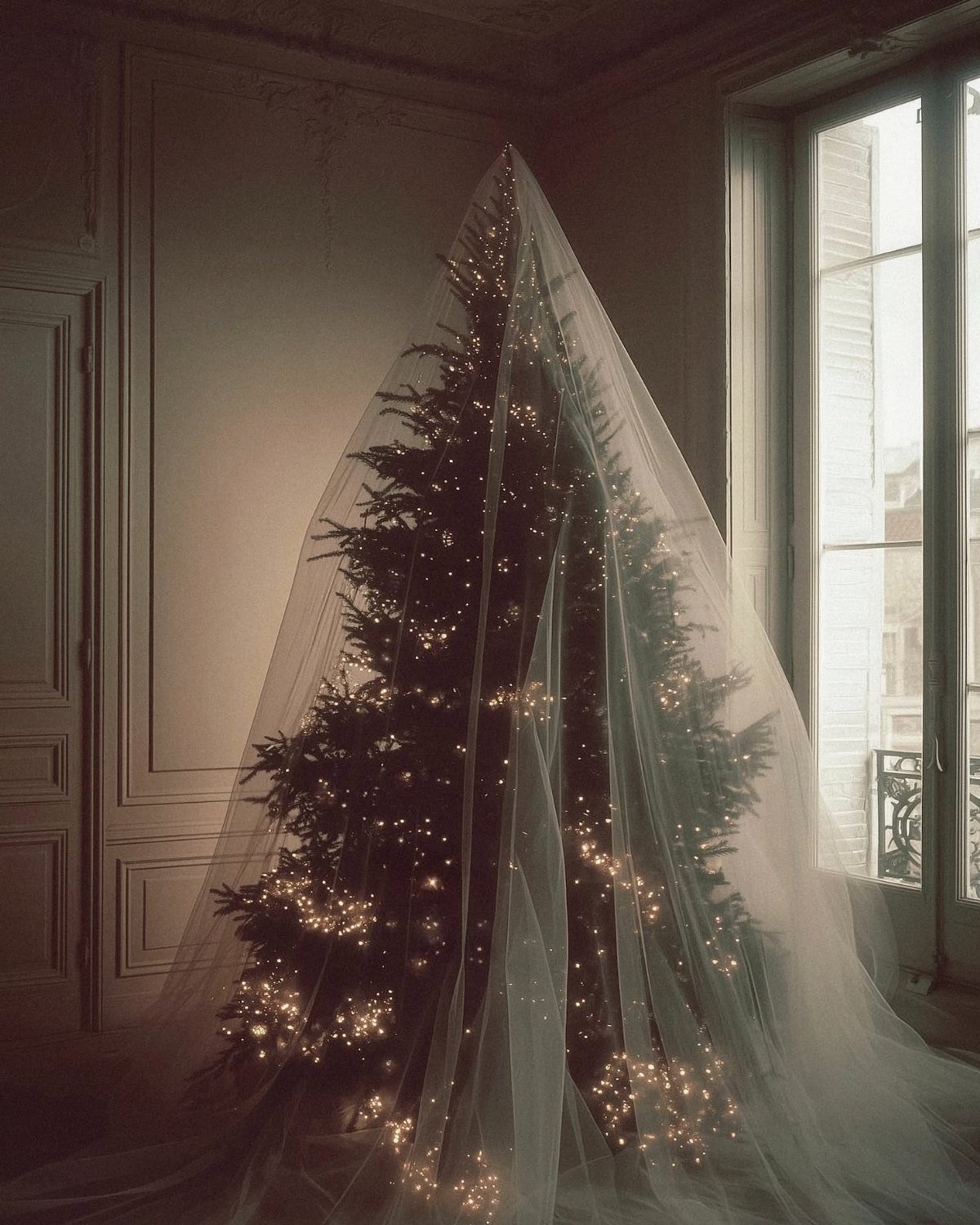 14 Modern Christmas Living Room Ideas with Photos 14 Christmas tree with fairy lights draped in sheer white fabric by a window