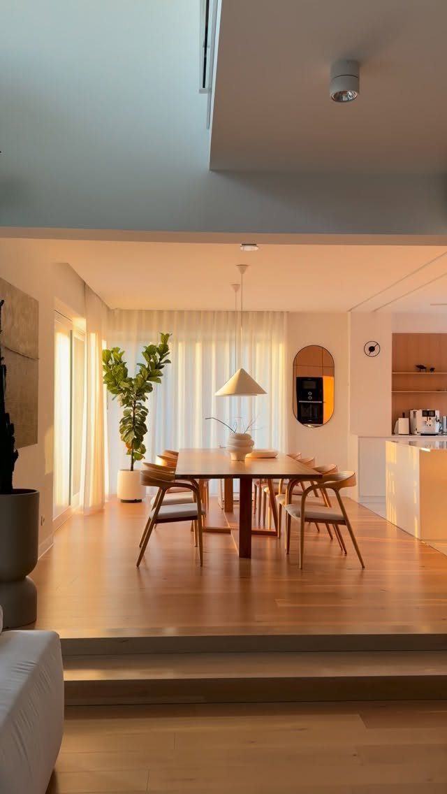 Modern dining room with a wooden table and a white conical pendant light.