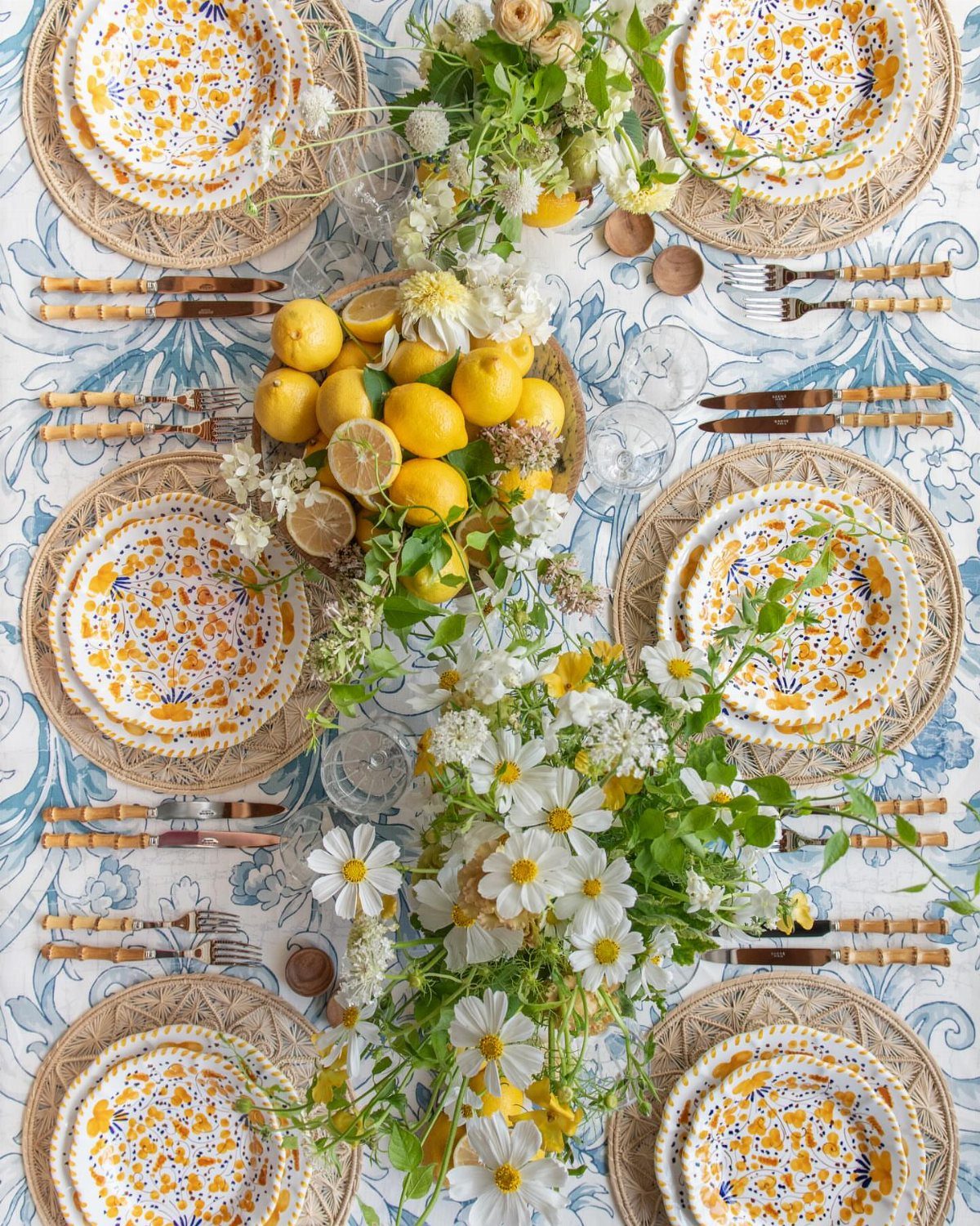 13 Modern Elegant Dining Room Ideas with Photos 6 Yellow and blue patterned plates on a blue patterned tablecloth with fresh lemons.