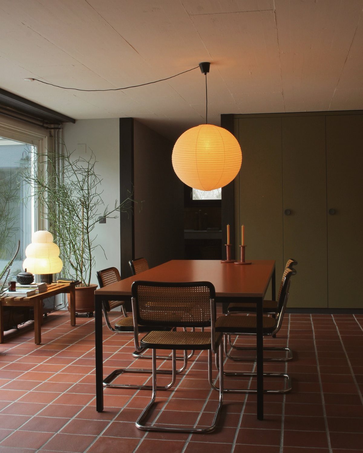 13 Modern Elegant Dining Room Ideas with Photos 11 Mid-century modern dining room with a wooden table, cane chairs, and spherical paper lamp.