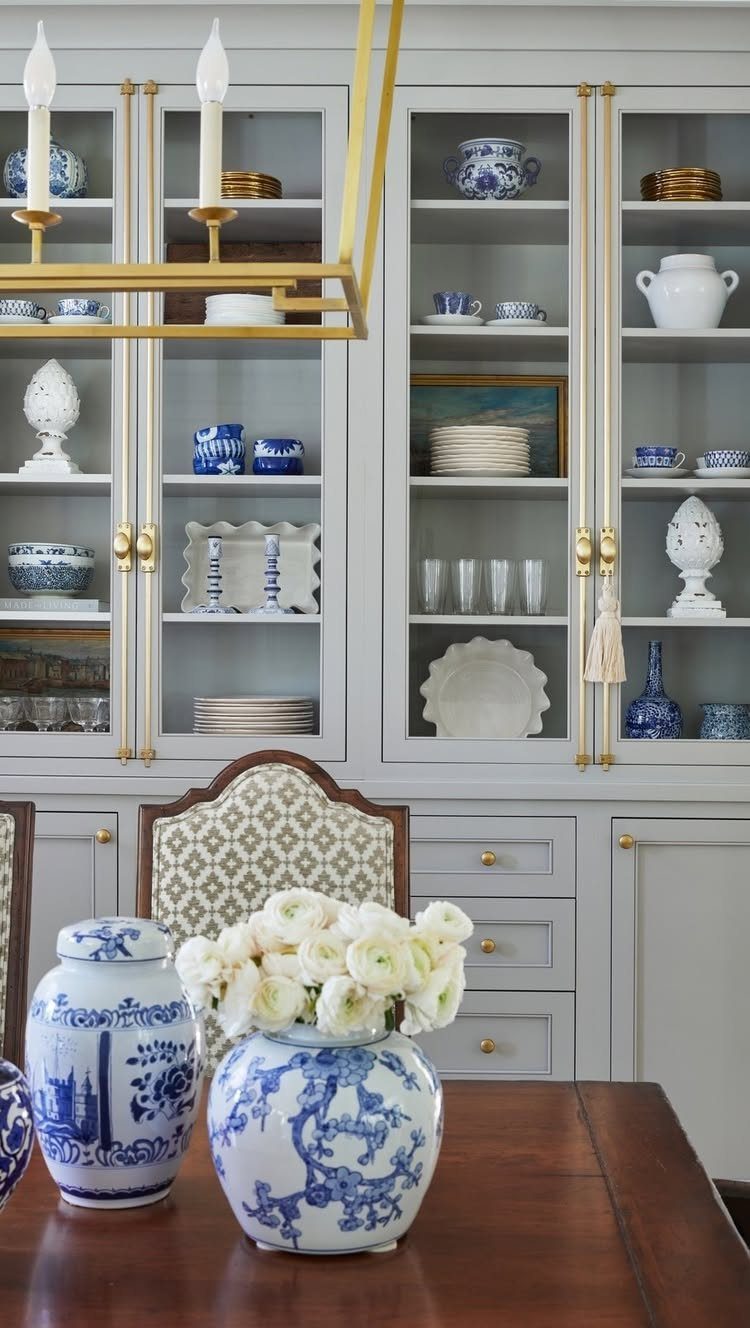 14 Modern Farmhouse Dining Room Ideas with Style 14 Dining room with wooden table, blue and white porcelain, and grey built-in cabinets.