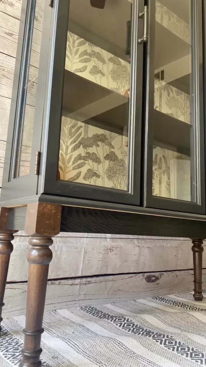 14 Modern Farmhouse Dining Room Ideas with Style 13 Grey china cabinet with glass doors and botanical wallpaper lining on a rug.