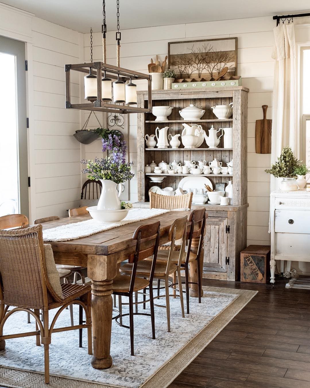 14 Modern Farmhouse Dining Room Ideas with Style 2 Wooden dining table with mixed woven and wooden chairs in a farmhouse room.