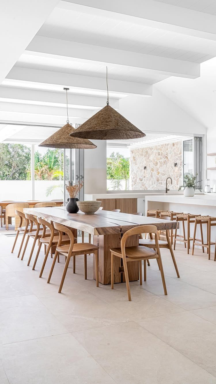 14 Modern Farmhouse Dining Room Ideas with Style 10 Long light-wood dining table with matching chairs under two woven pendant lights.