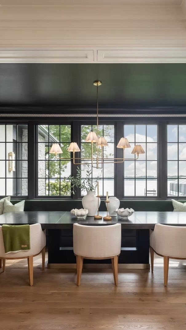 23 Modern Luxury Dining Room Ideas with Photos 13 Dining room with a dark green banquette seat, black table, and gold chandelier.
