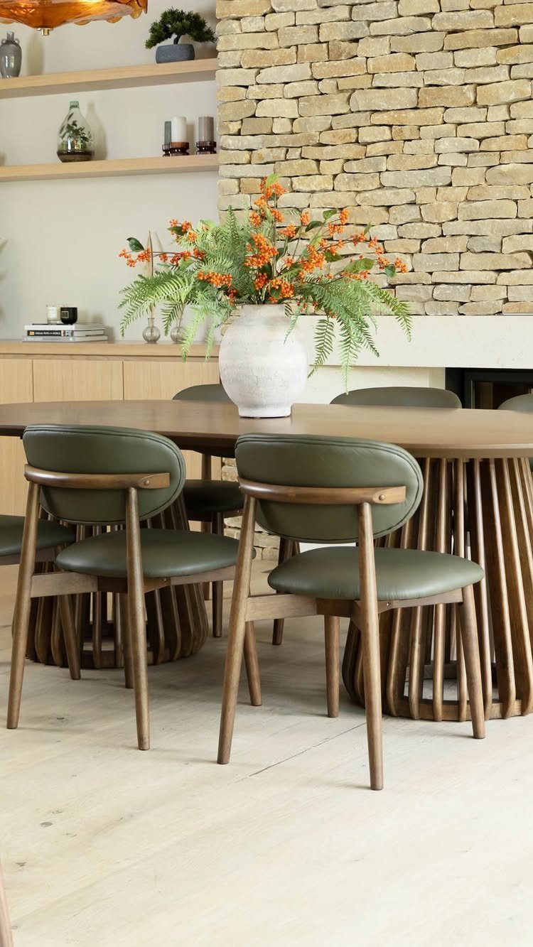 23 Modern Luxury Dining Room Ideas with Photos 18 Oval wooden dining table with olive green leather chairs and a stone wall background
