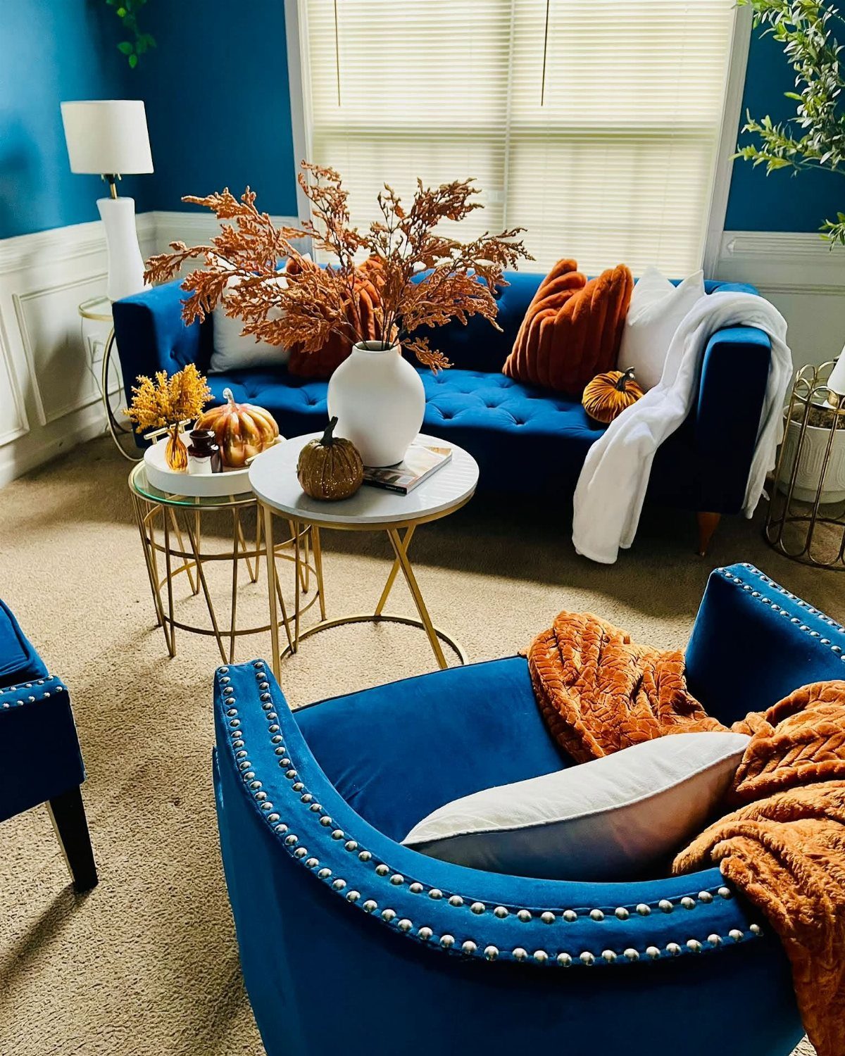 7 Navy Blue Fall Decor Ideas for a Cozy Seasonal Home 6 Navy blue velvet living room furniture decorated with orange autumn leaves and pumpkins.
