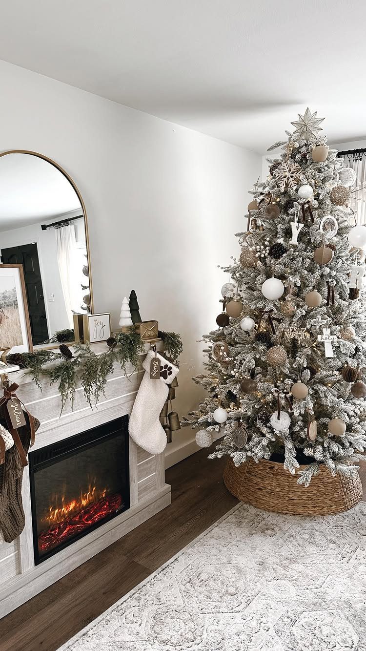 10 Neutral Color Christmas Decor Ideas for a Cozy Home 8 Flocked Christmas tree with various sized neutral ornaments next to a white fireplace mantel.
