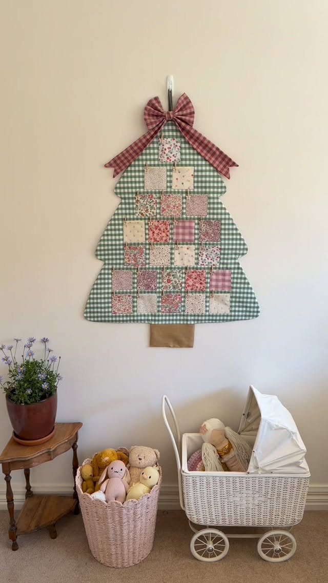 29 New Ideas for Christmas Decorating to Try in 2026 8 Fabric Christmas tree advent calendar with patterned pockets hanging on a white wall.