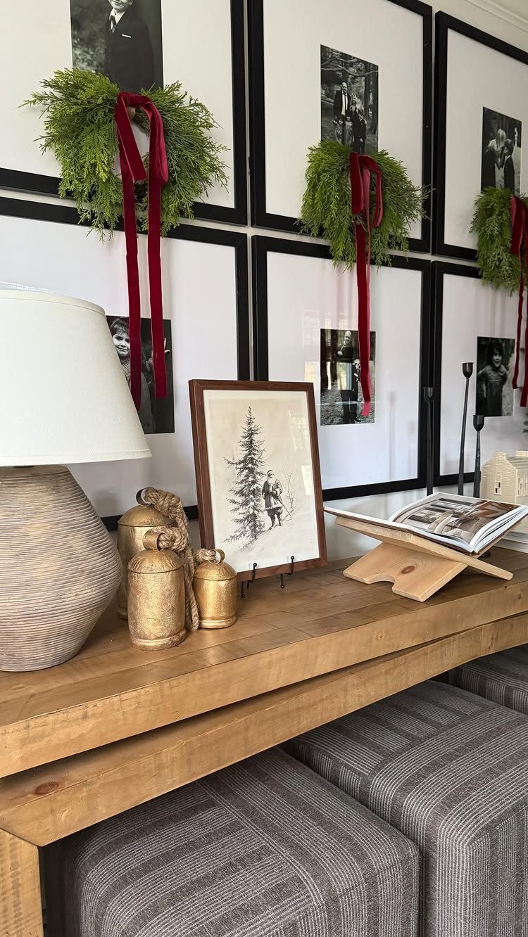 29 New Ideas for Christmas Decorating to Try in 2026 27 Green evergreen wreaths with red ribbons decorating black-framed photographs on a white wall.