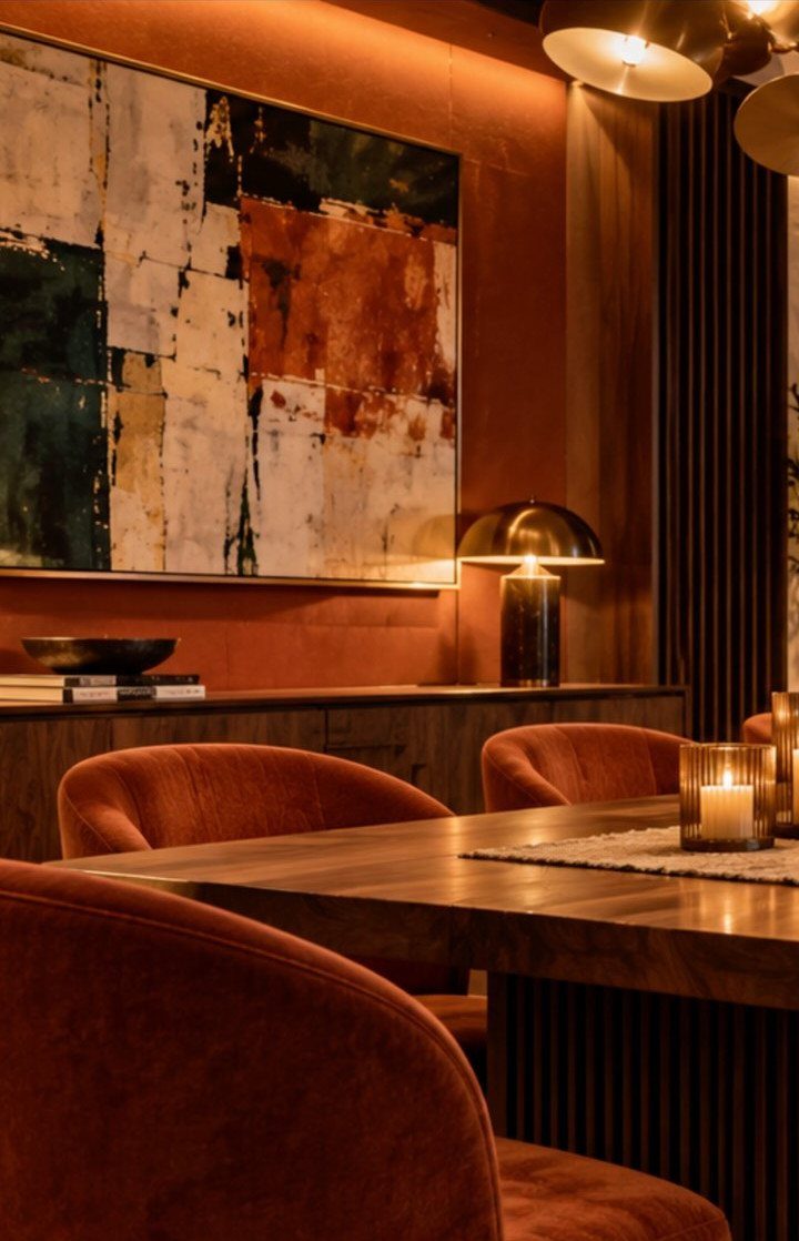 9 Old Money Dining Room Ideas for Timeless Elegance 3 Plush curved orange velvet dining chairs around a dark wooden table in a moody room.